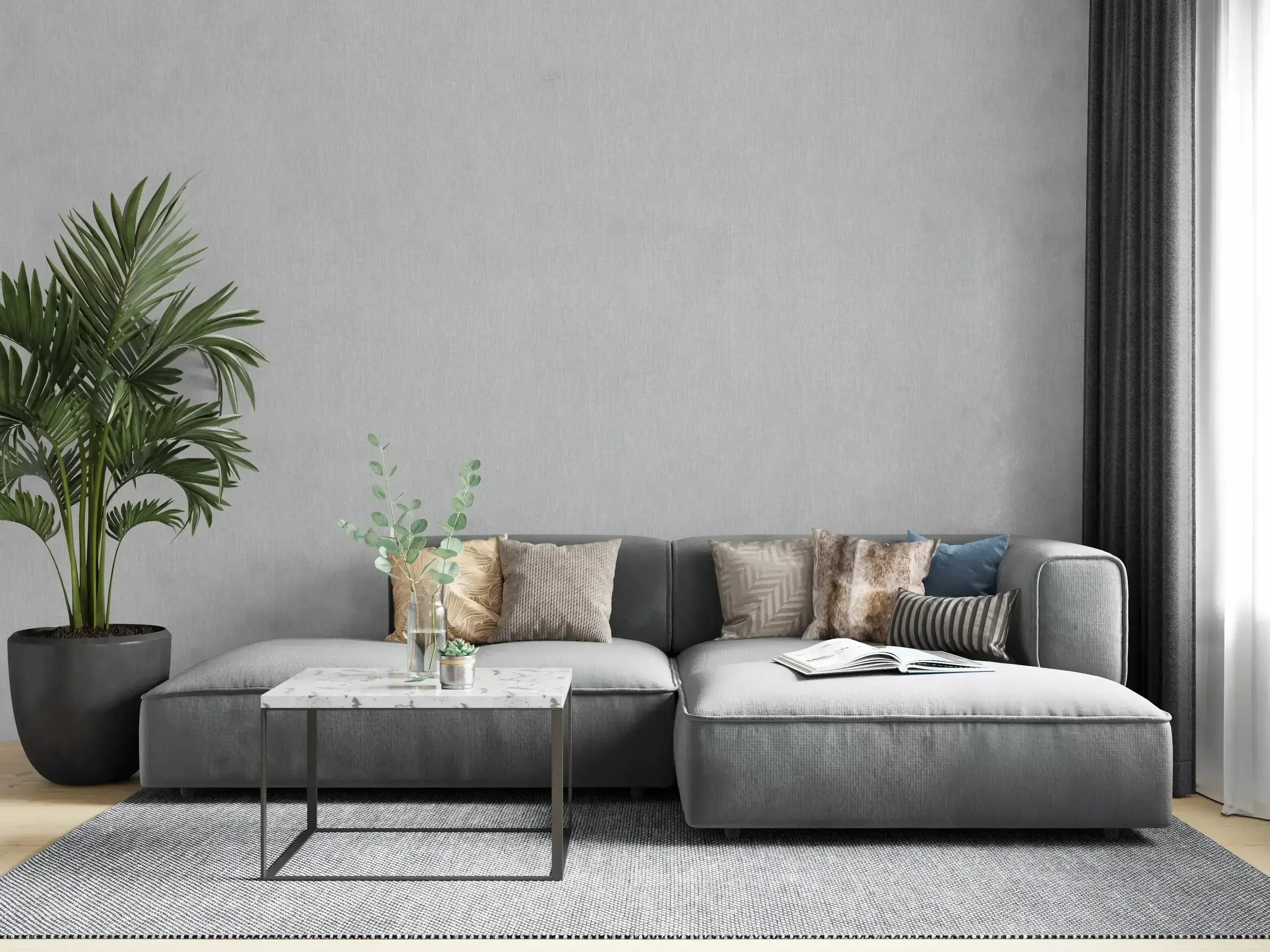 Moderne stue med Botanic Texture - Limestone tapet som baggrund, grå sofa og grøn plante.