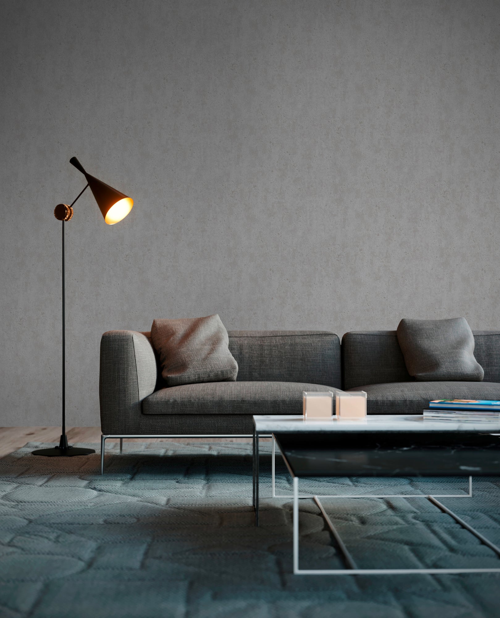 Stueindretning med en sofa, lampe og sofabord, hvor Concrete Chic - Slate tapetet fra Nicetapet.dk danner en elegant grå vægbaggrund.