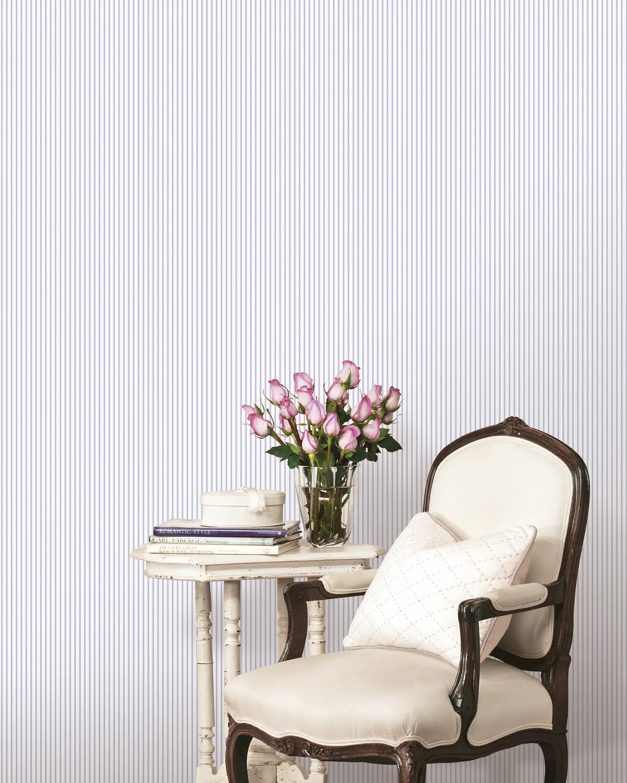 Elegant Lines - Dusk Lavender tapet viser en elegant stue med lænestol, sidebord og blomster, der fremhæver tapetets sofistikerede design.