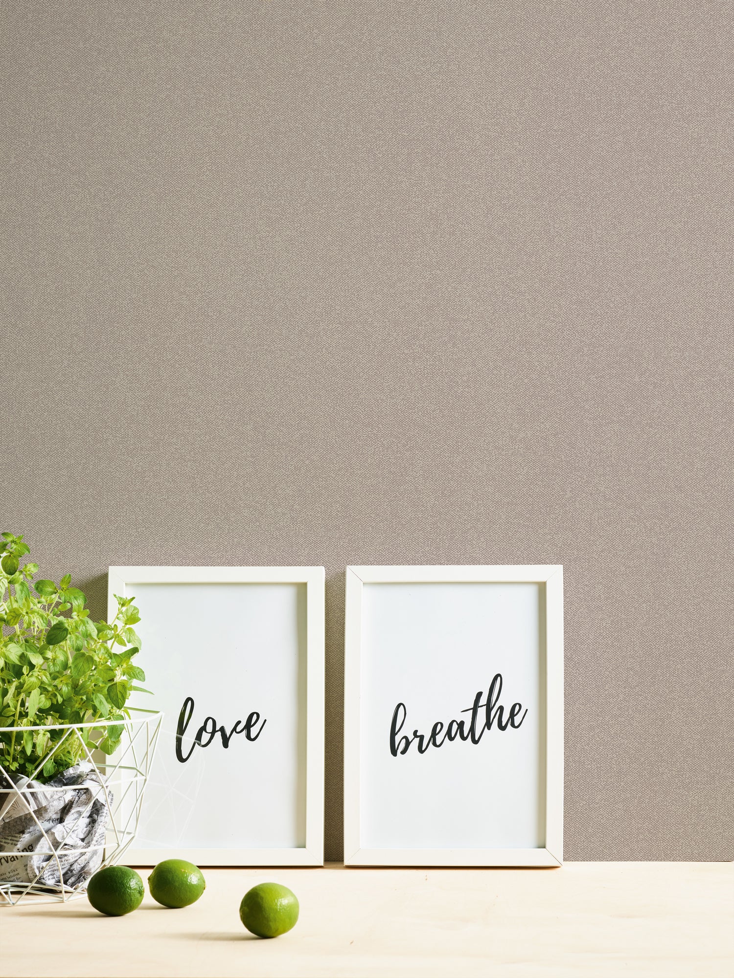 Imperial Linen - Pearl på væggen med to billeder med teksten 'love' og 'breathe', sammen med limefrugter og en plante.