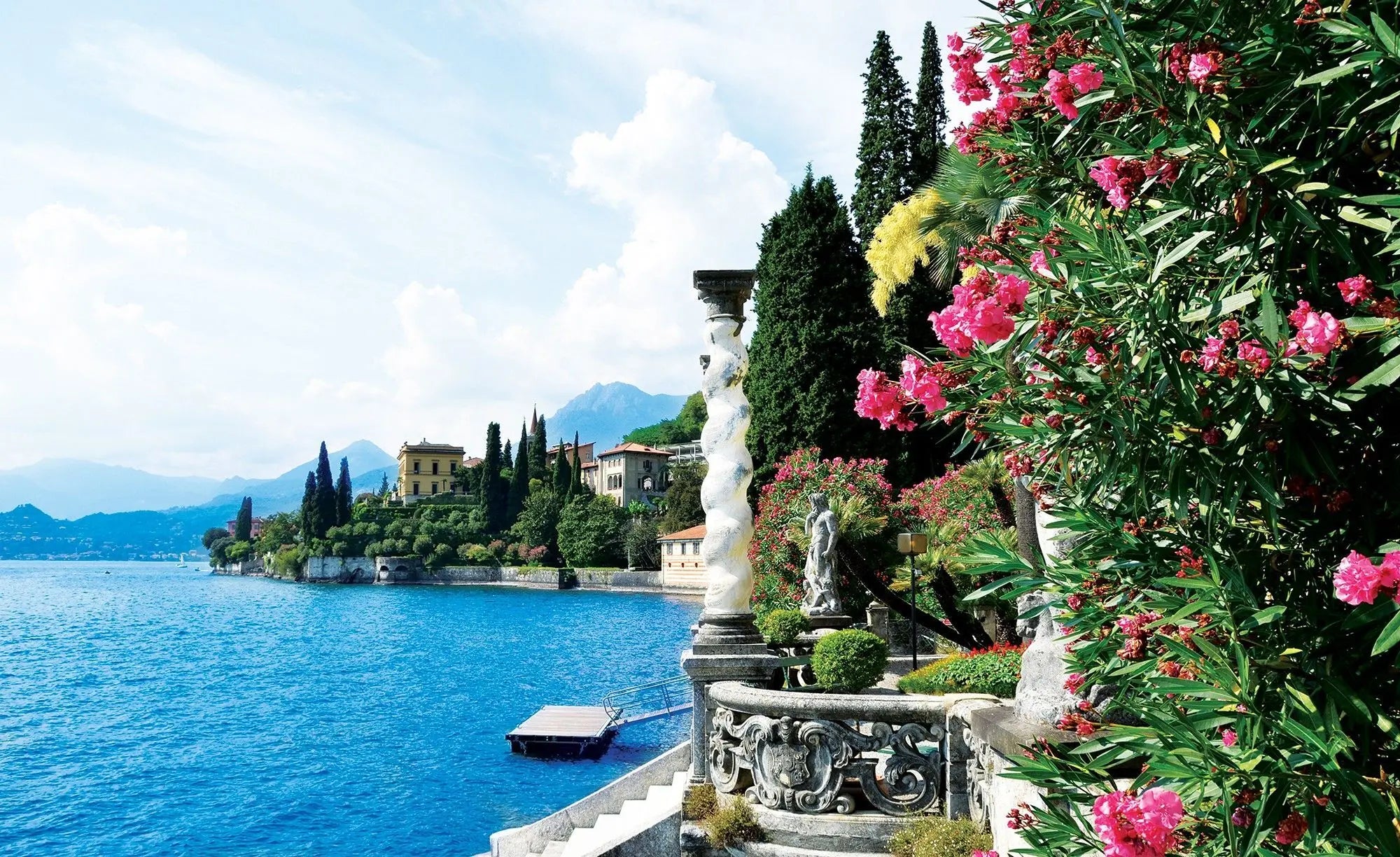 Billede 1 af Fototapet - Kystlandskab ved Comosøen i Italien med blomstrende buske og statuer