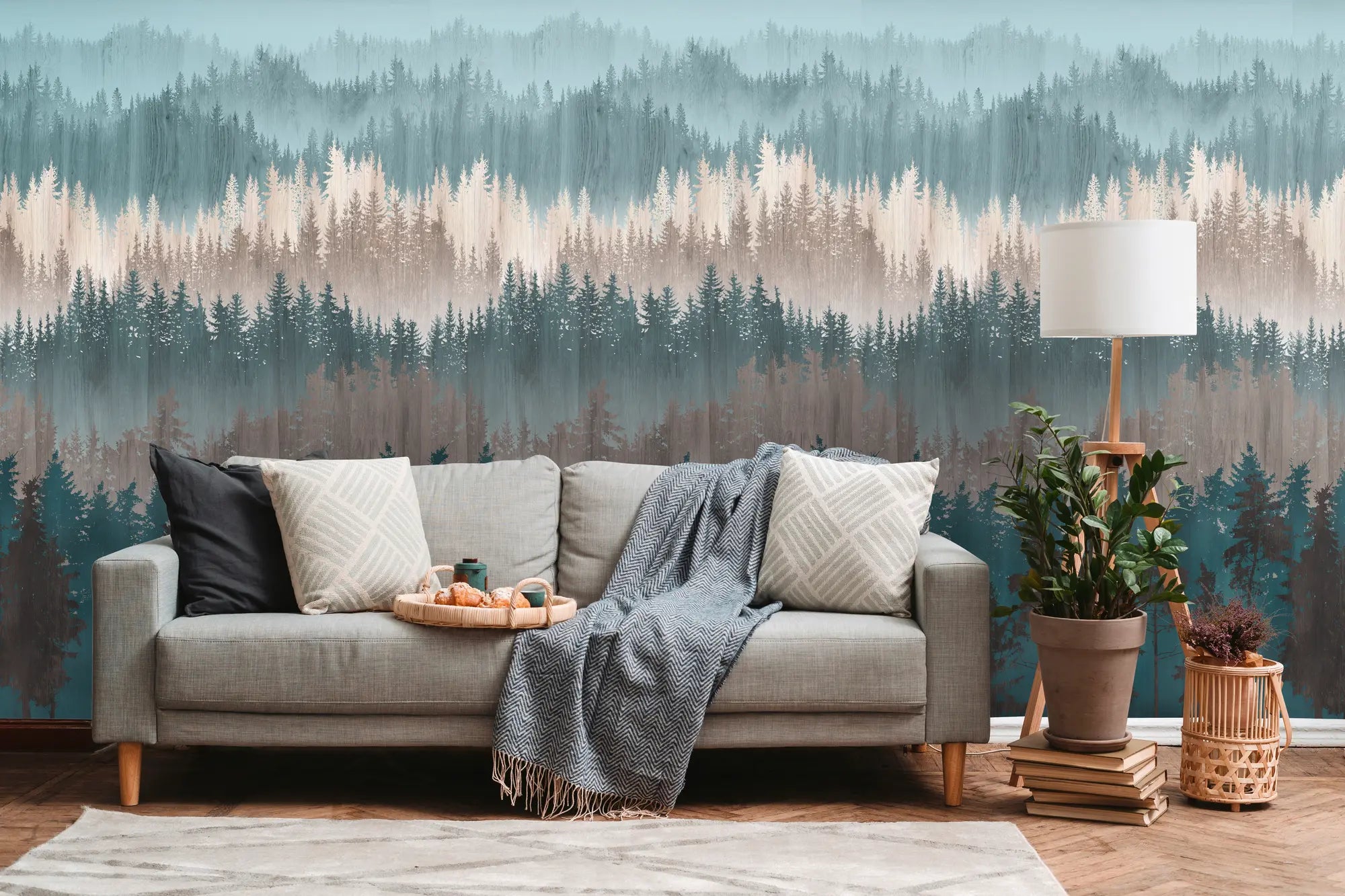 Et hyggeligt rum med 'Layered Forest - Tranquil' tapet fra Nicetapet.dk som baggrund, indrettet med sofa, tæppe, og planter.