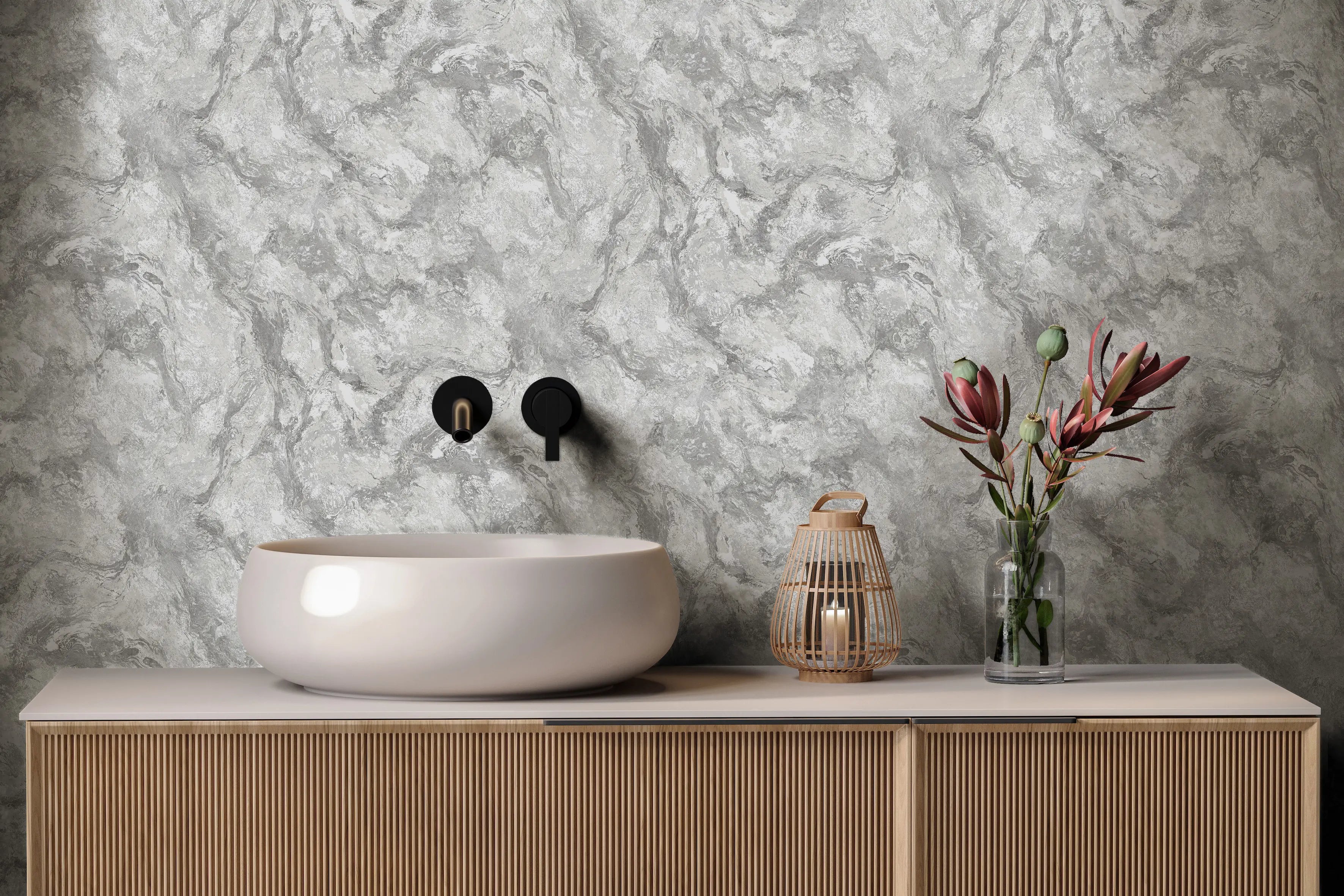 Levanto Marble - Dove Silver tapet fra Nicetapet.dk brugt som vægbeklædning i et moderne badeværelse med en hvid håndvask, dekorative blomster og en lanterne.