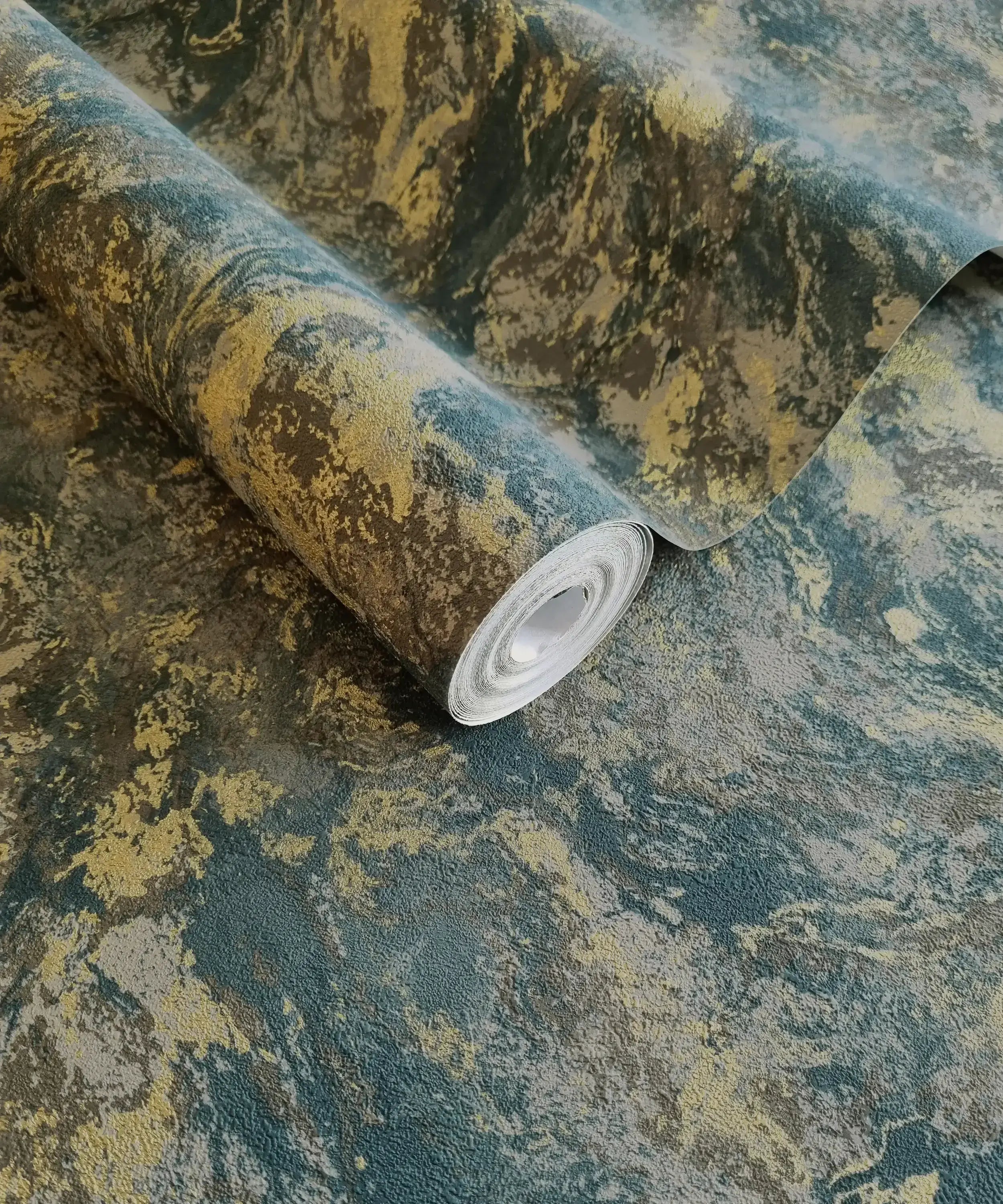 Nærbillede af en Levanto Marble - Teal tapetrulle, der viser de blå og gyldne marmorlignende mønstre.