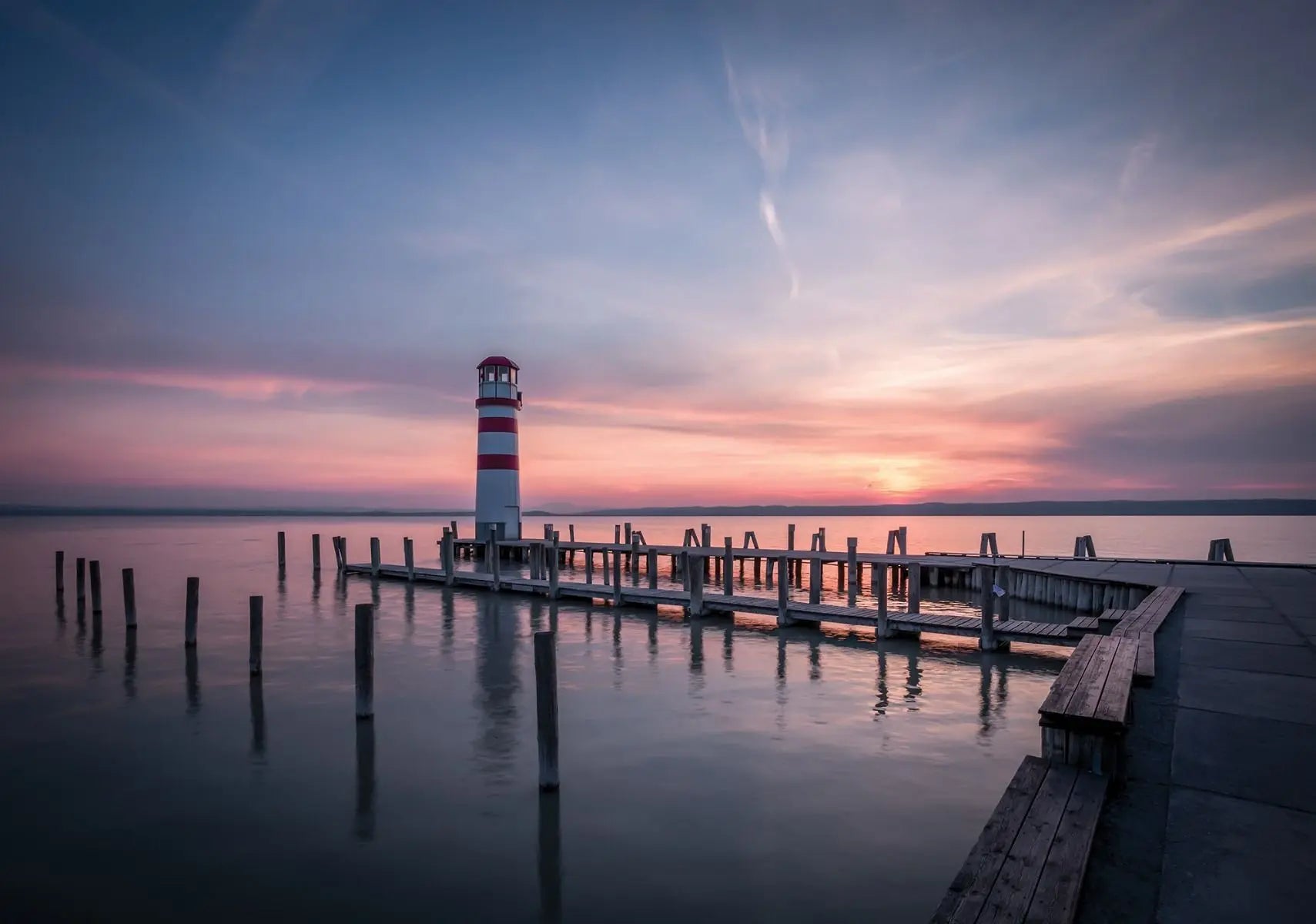 Billede 1 af Fototapet - Rød og hvidt fyrtårn ved mole under solnedgang