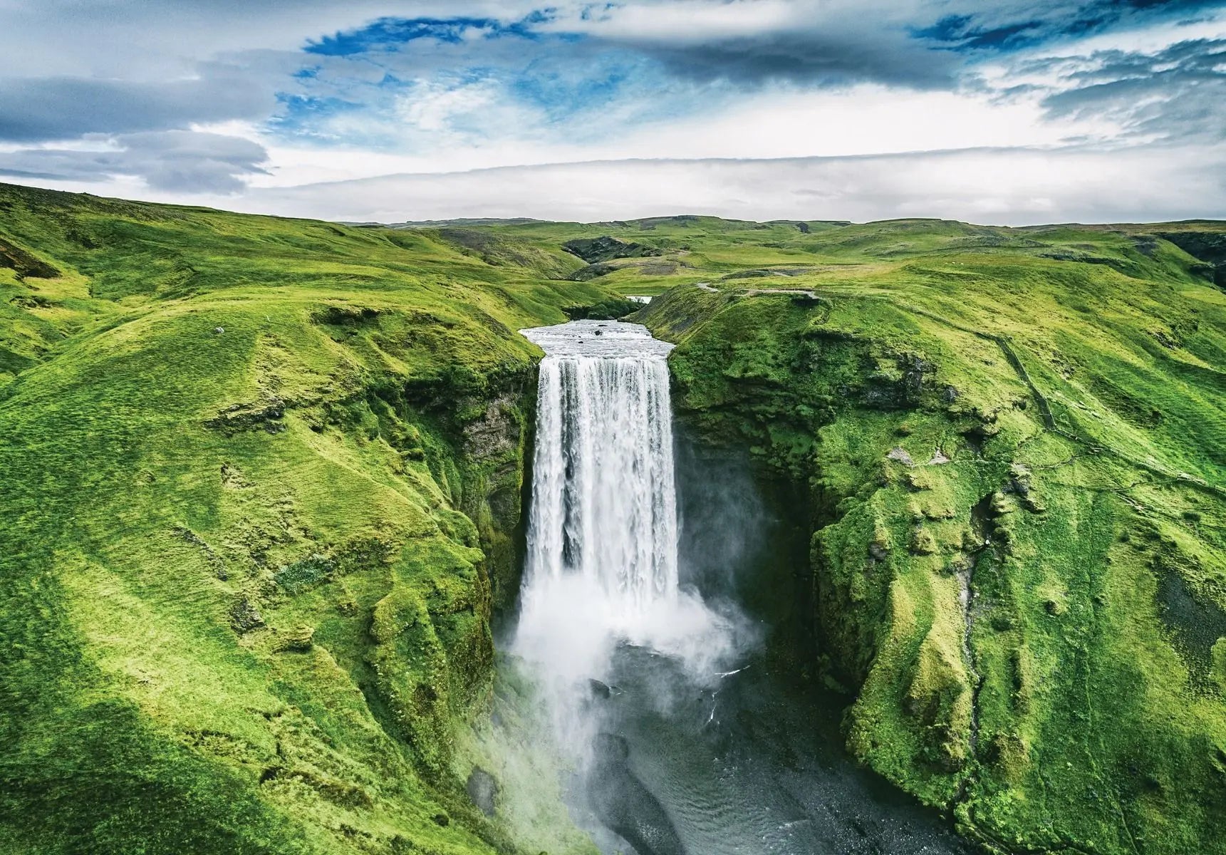 Billede 1 af Fototapet - Skógafoss vandfald omkranset af grønne bakker i Island