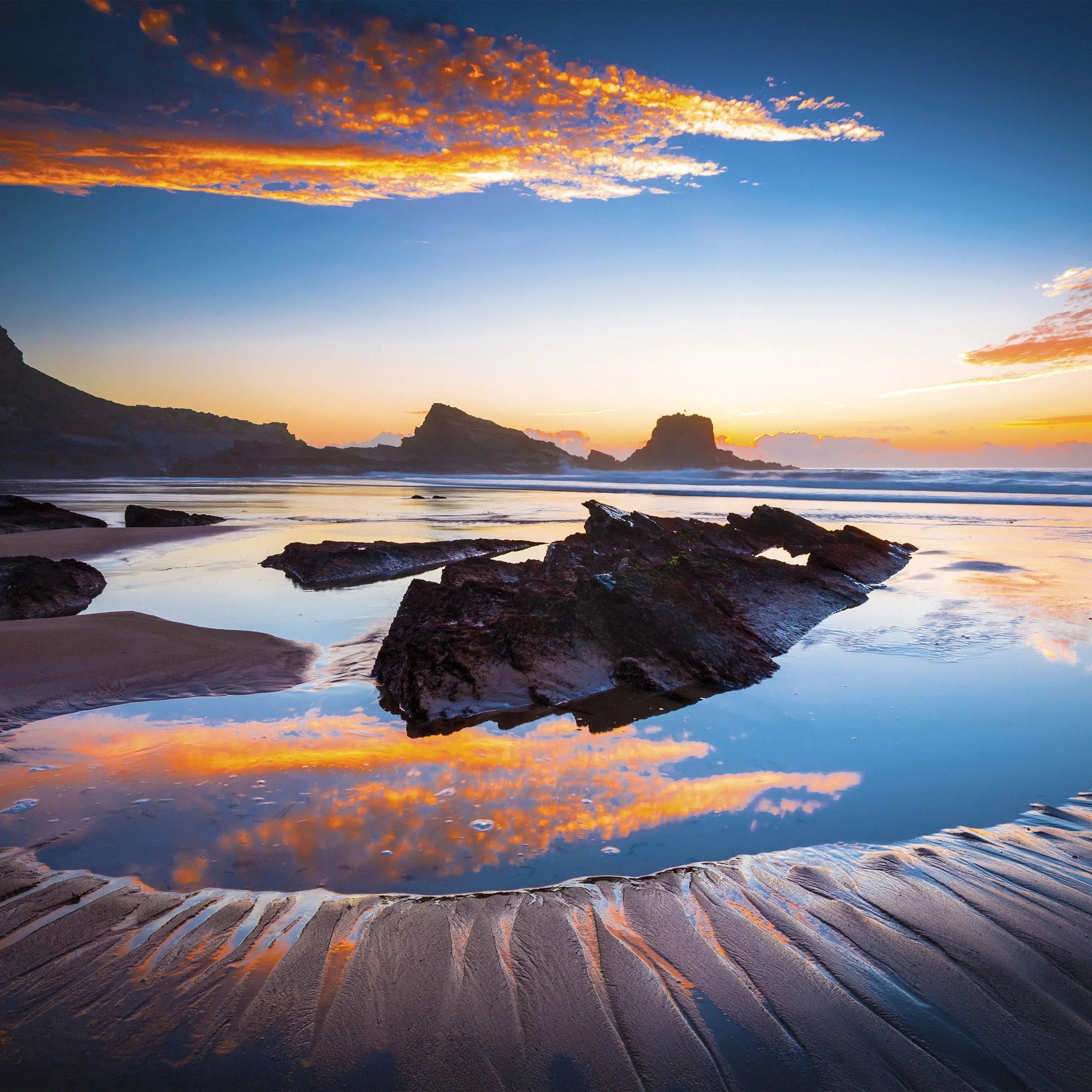 Billede 7 af Fototapet - Stenstrand med solnedgang og vandoverfladerefleksion