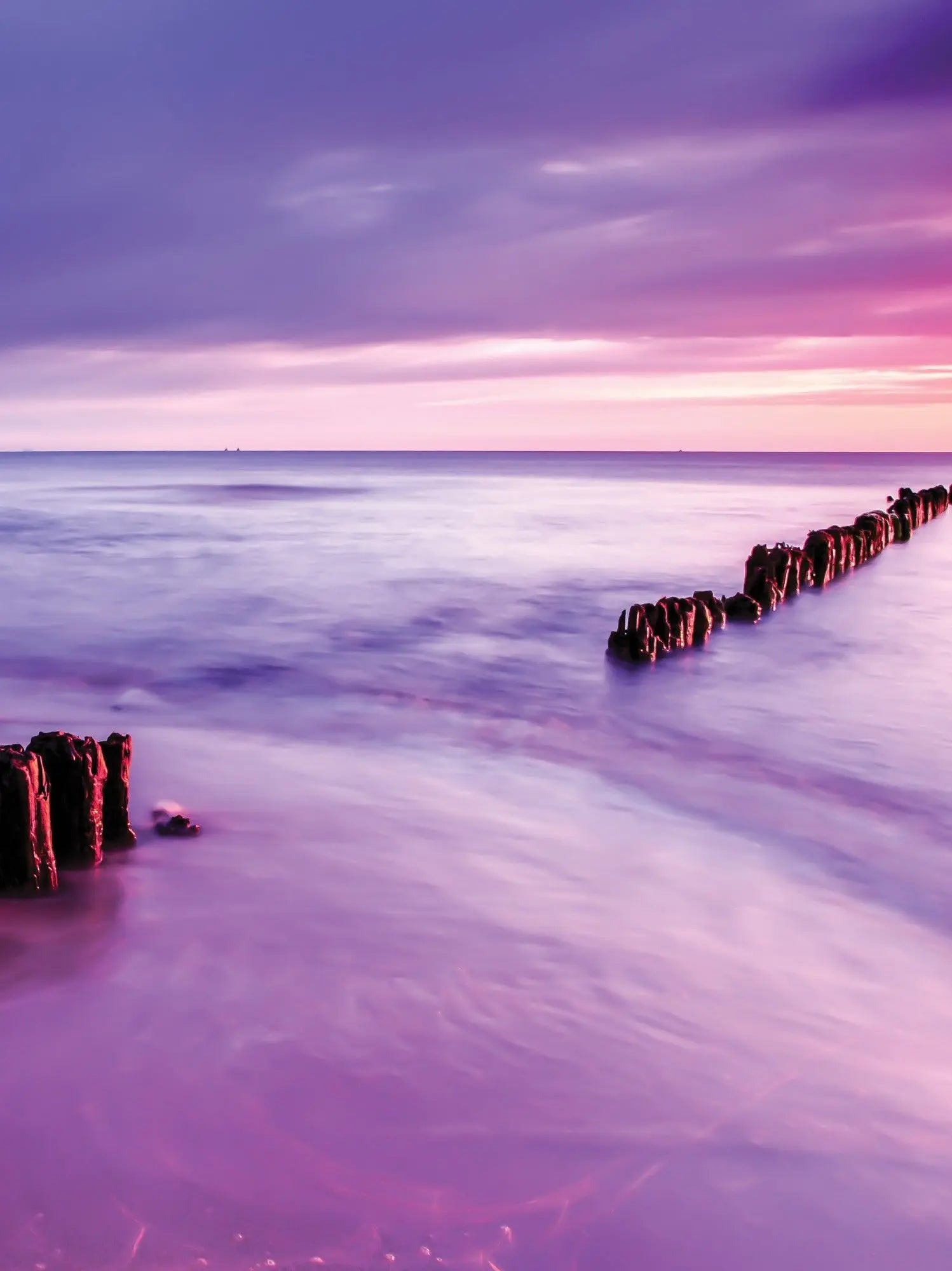 Billede 8 af Fototapet - Strand med bølgebryder og lilla solnedgang