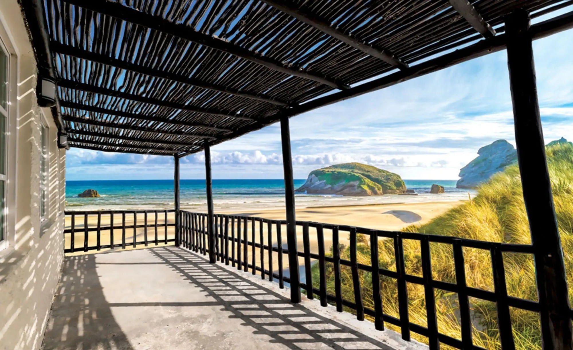 Billede 1 af Fototapet - Terrasse med sort træpergola og udsigt til strand og klippeø