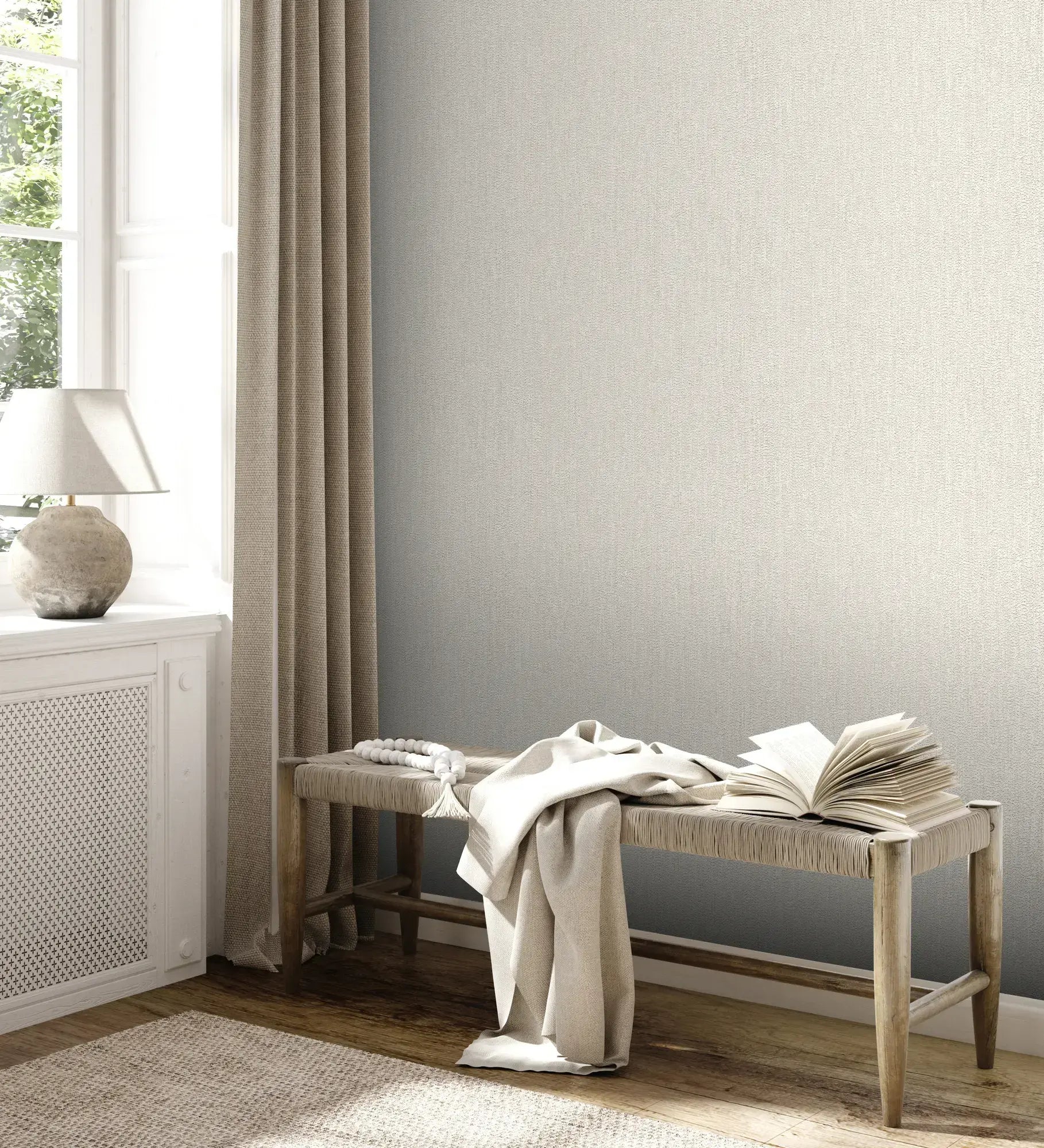 Interiørbillede med Textured Calm - Ivory tapet på væggen, komplet med en bænk, åbne bøger og naturlige tekstiler ved siden af et vindue.