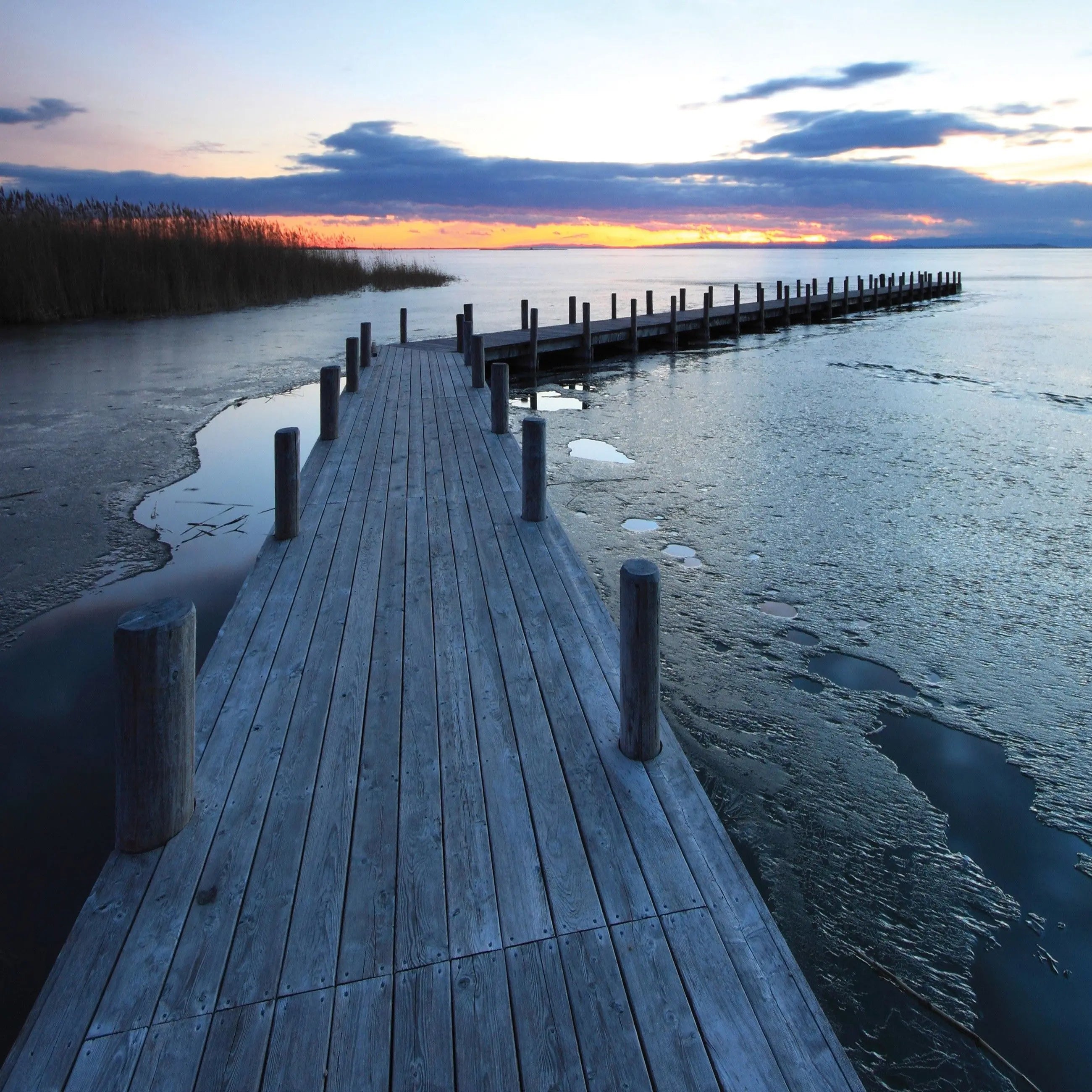 Billede 13 af Fototapet - Træbrygge ved solnedgang med delvist isdækket vand