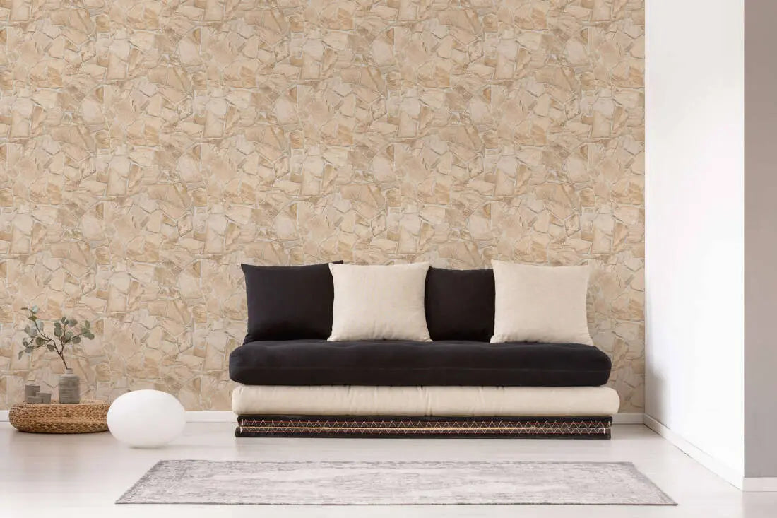 Urban Patchwork - Sandstone tapet i en stue med sort sofa og beige puder.